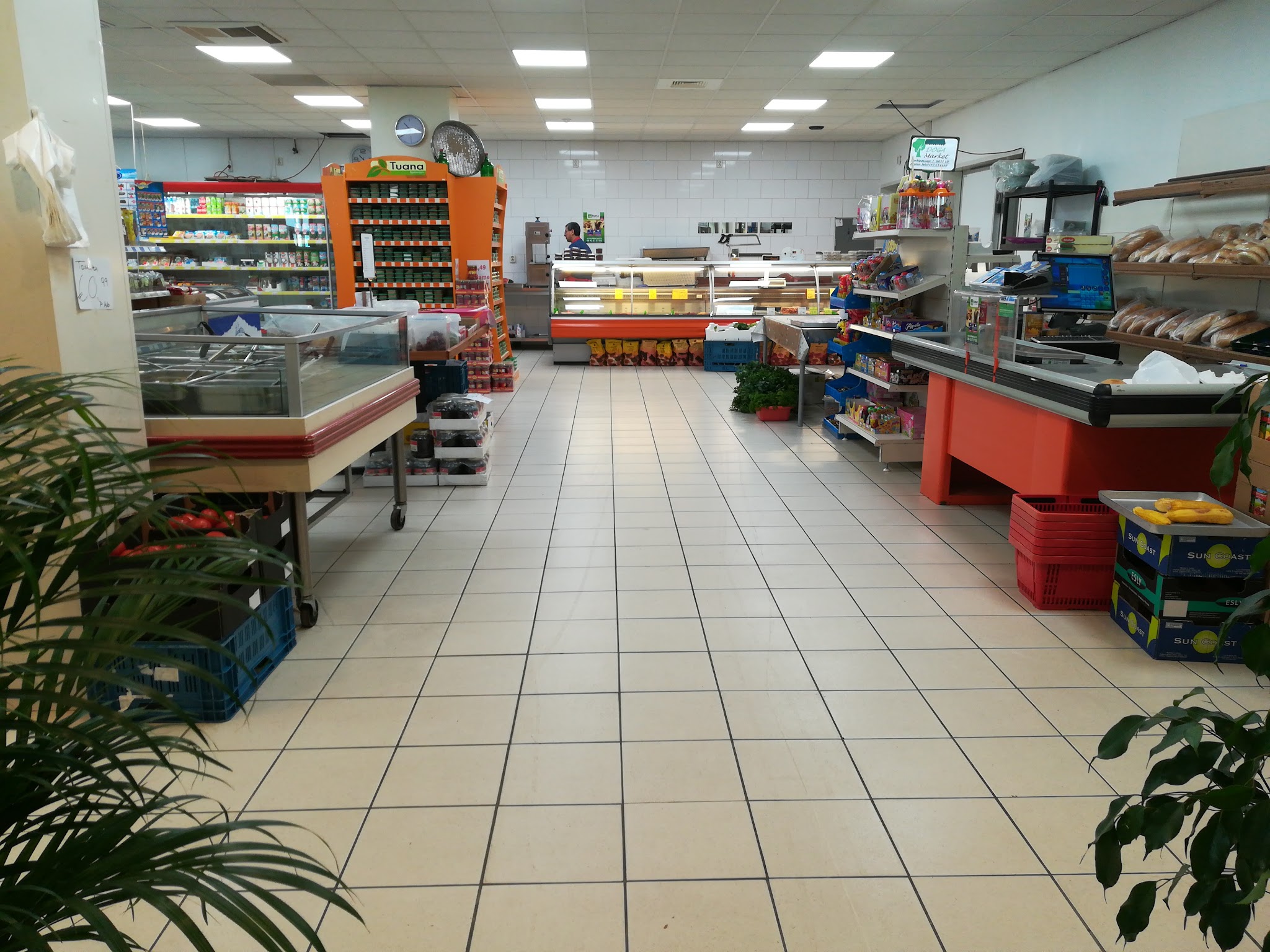 Een kijkje in de ruime supermarkt van Doga Market met de boodschappenrekken en gekoelde toonbanken
