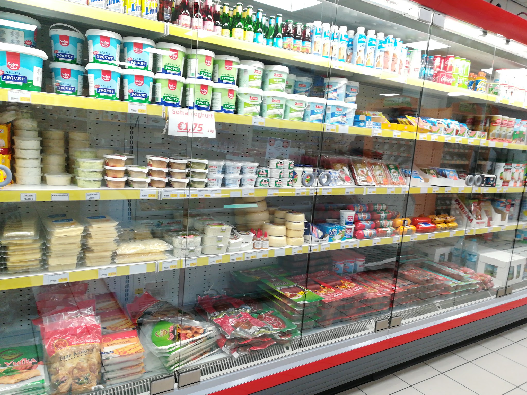Het gekoelde assortiment met kazen, olijven en andere boodschappen bij Doga Market